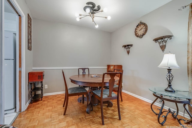 dining area featuring a chandelier and light parquet floors