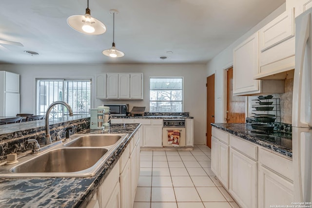 kitchen featuring sink, white cabinetry, hanging light fixtures, white refrigerator, and light tile patterned flooring