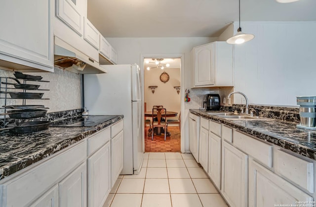 kitchen featuring white cabinetry, sink, backsplash, hanging light fixtures, and light tile patterned floors