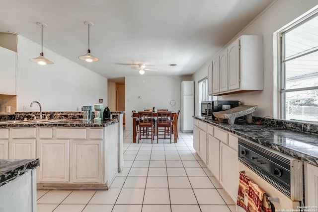 kitchen with pendant lighting, ceiling fan, a healthy amount of sunlight, and light tile patterned floors