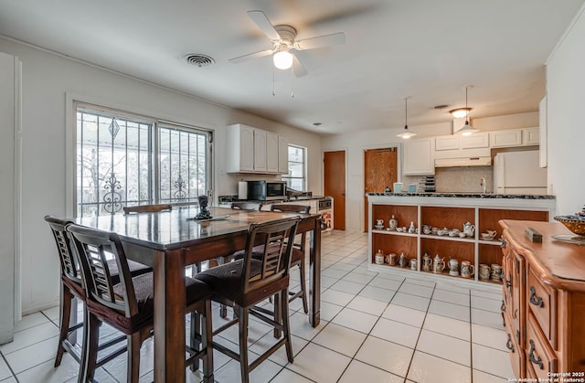 tiled dining area featuring ceiling fan