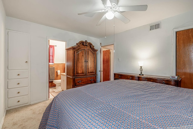 bedroom with connected bathroom, light carpet, and ceiling fan