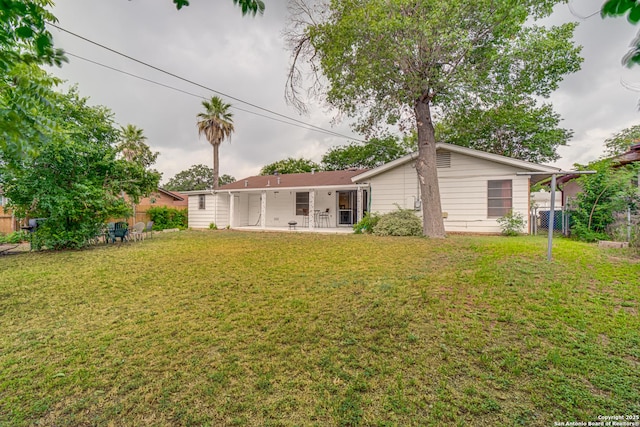 rear view of property with a patio and a yard