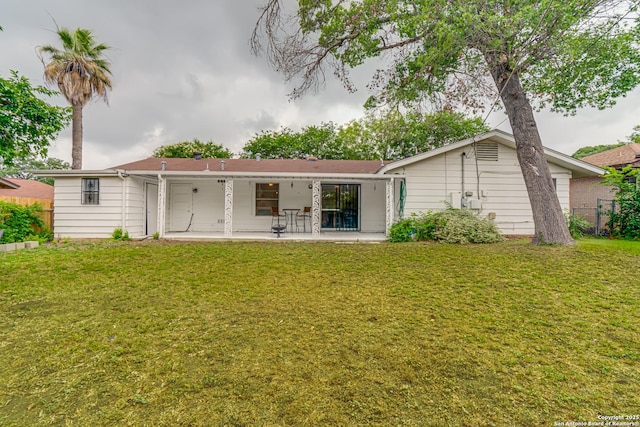 rear view of property featuring a patio area and a lawn