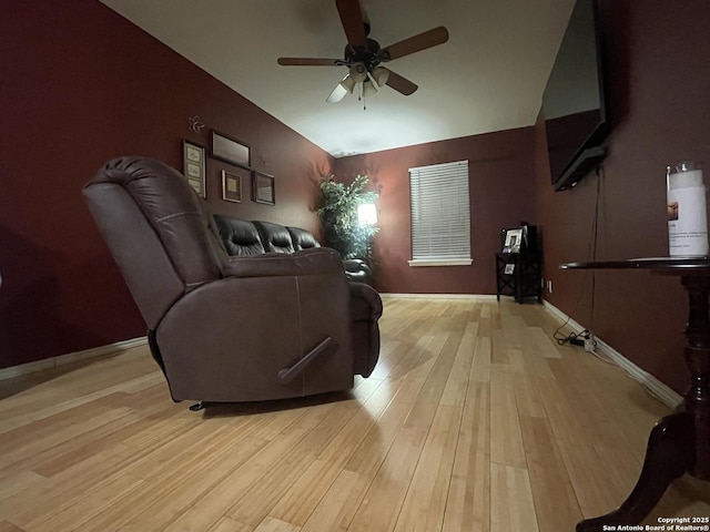 living room with ceiling fan, lofted ceiling, and light hardwood / wood-style flooring