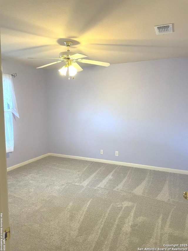 carpeted spare room featuring ceiling fan