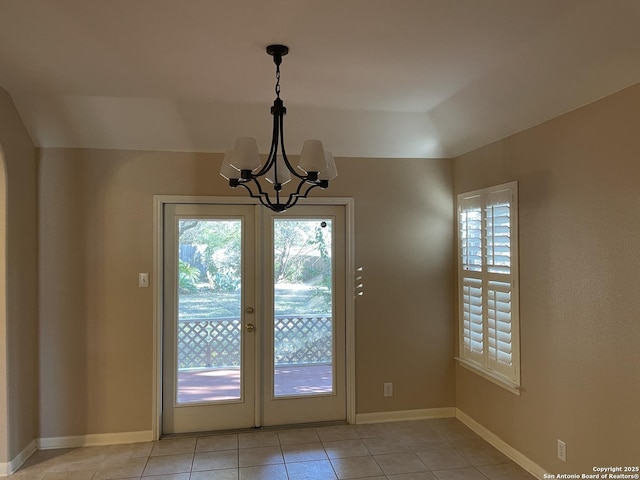 doorway featuring an inviting chandelier, light tile patterned flooring, and a wealth of natural light