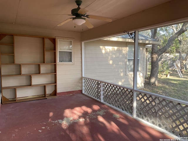 unfurnished sunroom featuring ceiling fan