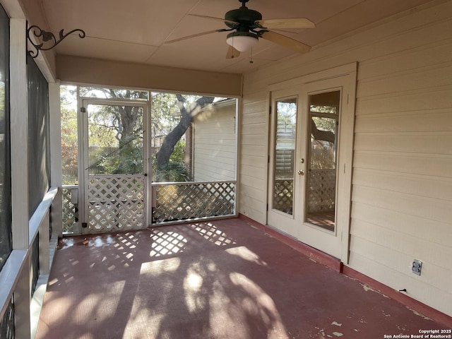 unfurnished sunroom featuring ceiling fan