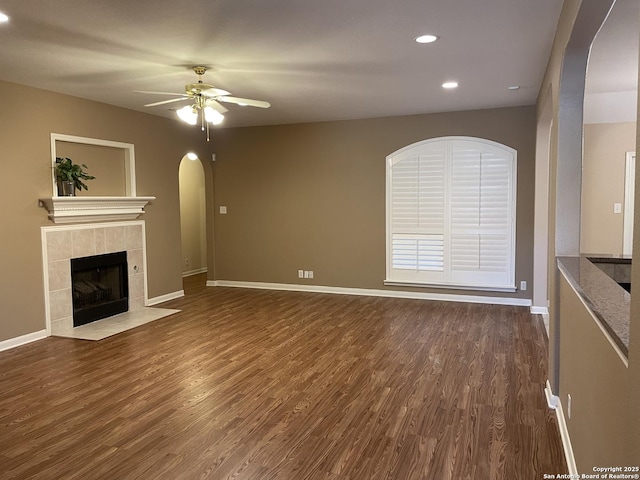 unfurnished living room featuring dark hardwood / wood-style flooring, a fireplace, and ceiling fan