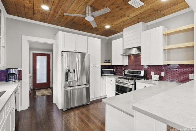 kitchen with wall chimney range hood, ornamental molding, stainless steel appliances, and white cabinets