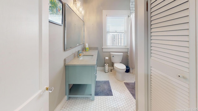 bathroom with tile patterned flooring, vanity, and toilet