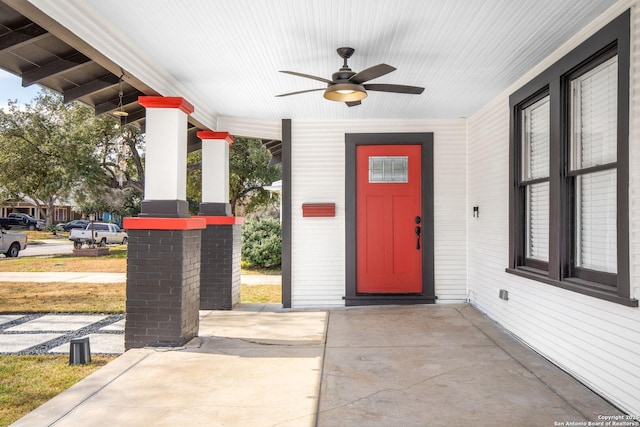 view of exterior entry featuring a porch and ceiling fan