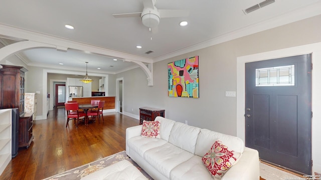 living room featuring ceiling fan, ornamental molding, and dark hardwood / wood-style floors