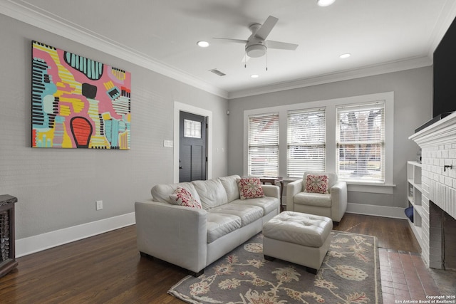 living room with ornamental molding, dark hardwood / wood-style flooring, ceiling fan, and a fireplace