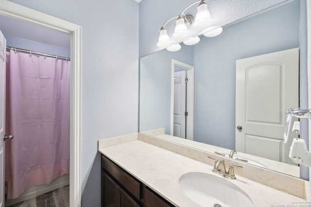 bathroom with hardwood / wood-style flooring, vanity, and a shower with shower curtain