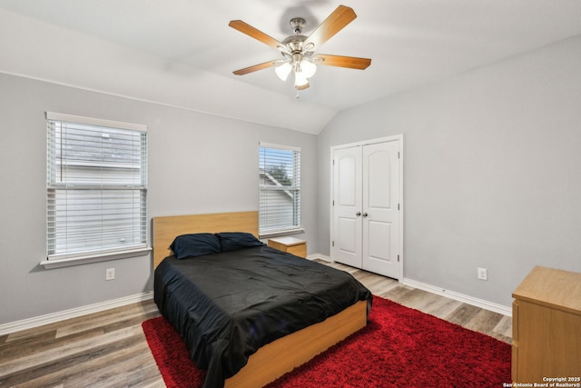 bedroom featuring hardwood / wood-style floors, vaulted ceiling, a closet, and ceiling fan