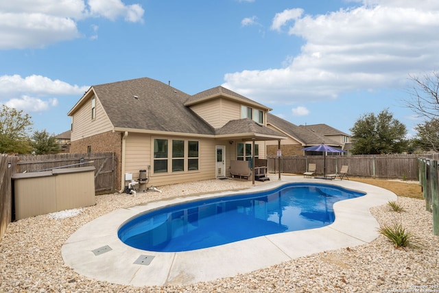 back of house featuring a fenced in pool and a patio