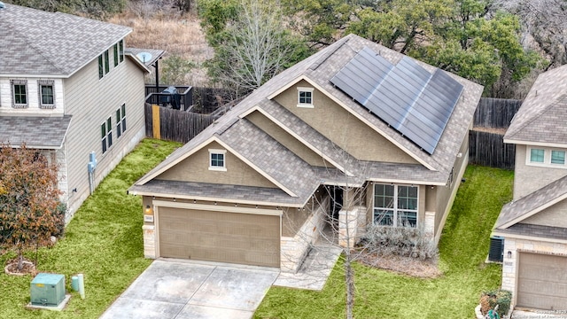 craftsman inspired home with a garage, a front lawn, and solar panels