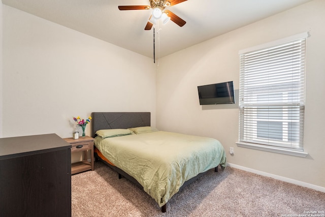 bedroom with ceiling fan, light colored carpet, and multiple windows