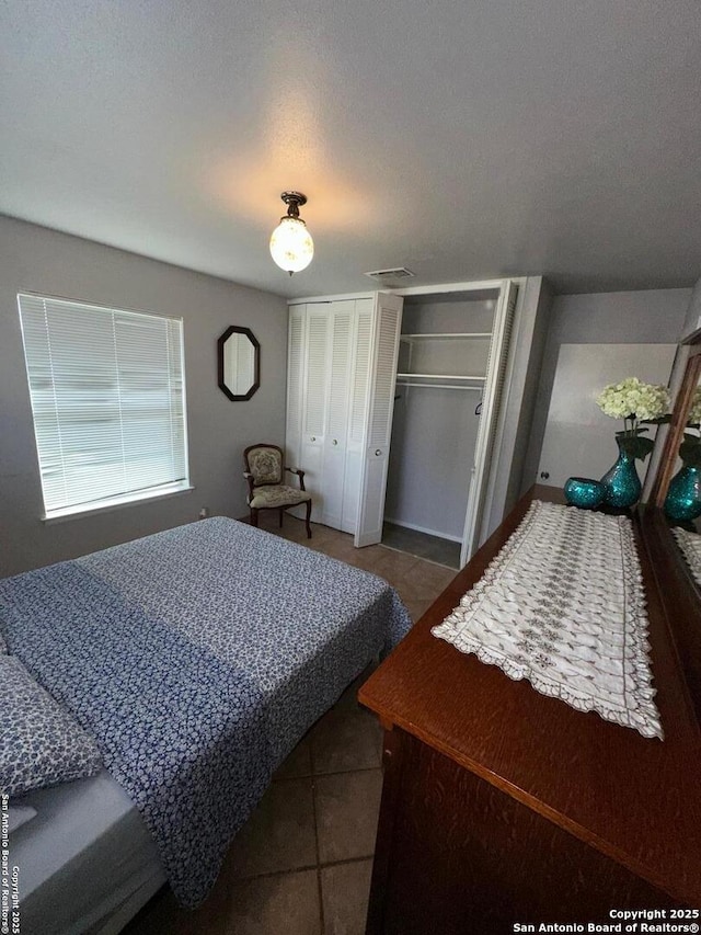 bedroom featuring tile patterned flooring and a closet