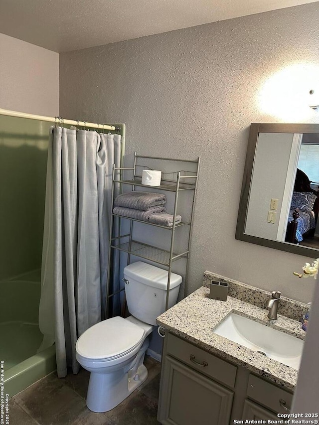 bathroom featuring vanity, toilet, and walk in shower