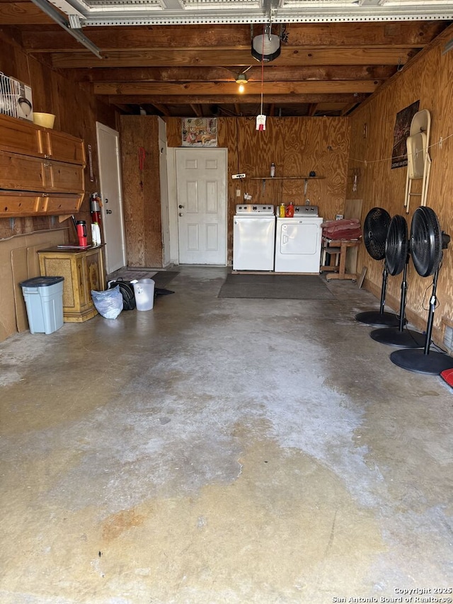 garage with a garage door opener and independent washer and dryer