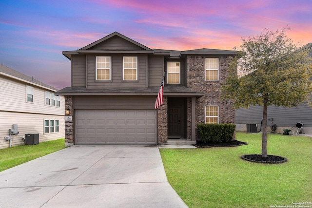 front facade featuring a garage, central AC unit, and a lawn