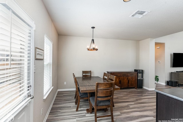 dining room featuring dark hardwood / wood-style flooring and an inviting chandelier