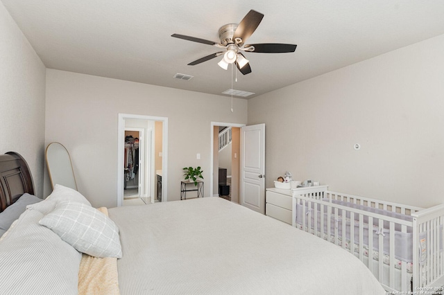 bedroom with ceiling fan and a walk in closet