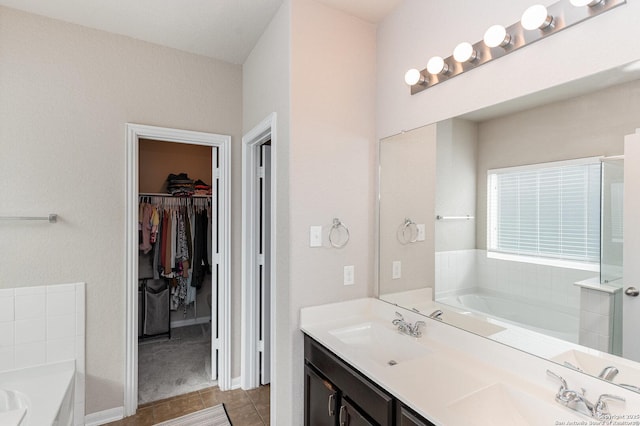 bathroom featuring vanity, tile patterned flooring, and a bathtub