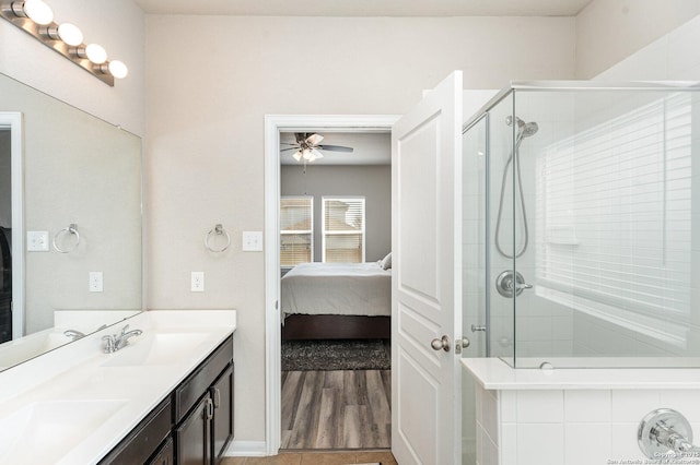 bathroom with vanity, a shower with shower door, and ceiling fan