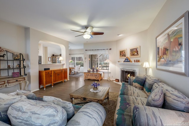 living room featuring ceiling fan and dark hardwood / wood-style flooring