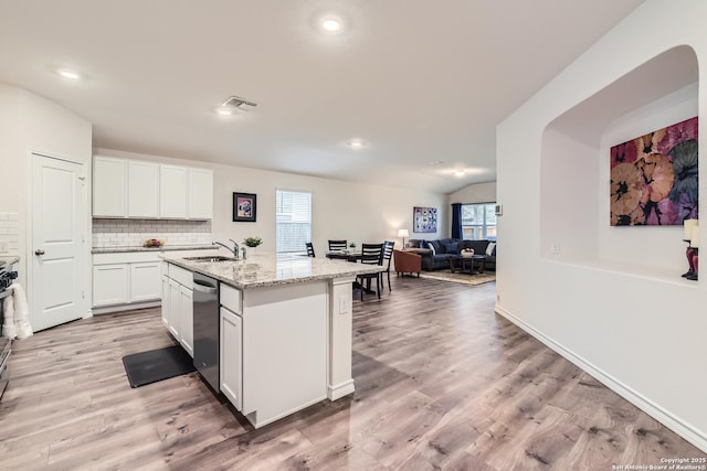 kitchen featuring dishwasher, white cabinetry, sink, light stone countertops, and a center island with sink