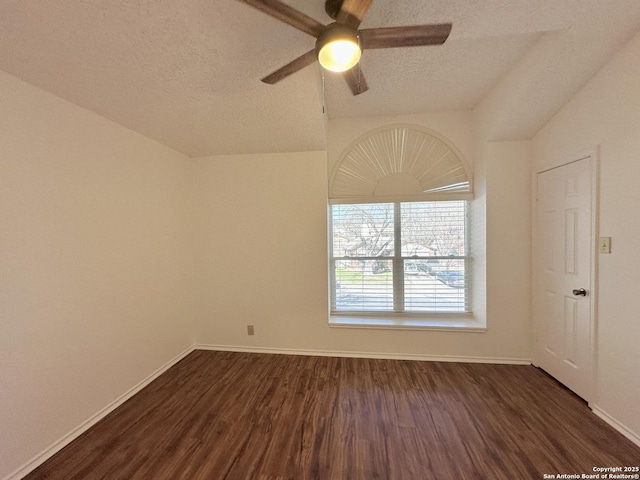 empty room featuring ceiling fan, dark wood-type flooring, and a textured ceiling