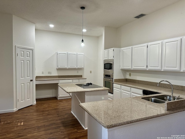 kitchen with pendant lighting, stainless steel appliances, sink, and white cabinets