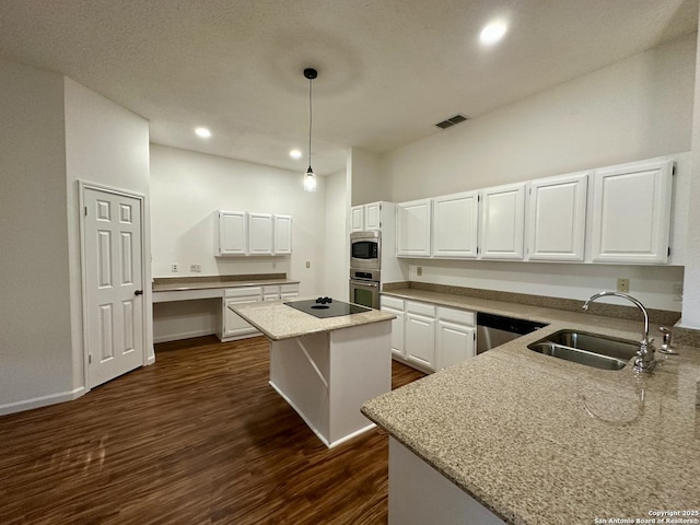 kitchen featuring light stone countertops, a kitchen island, pendant lighting, and white cabinets