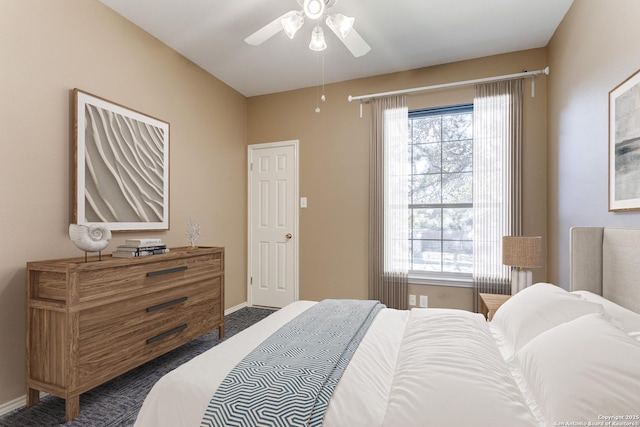 bedroom featuring multiple windows, ceiling fan, and dark colored carpet