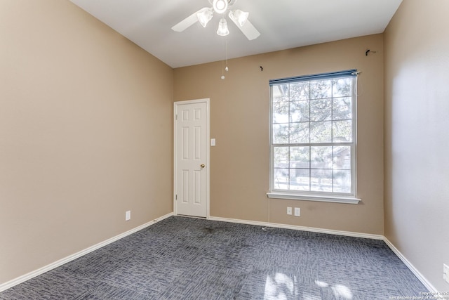 empty room featuring dark colored carpet and ceiling fan