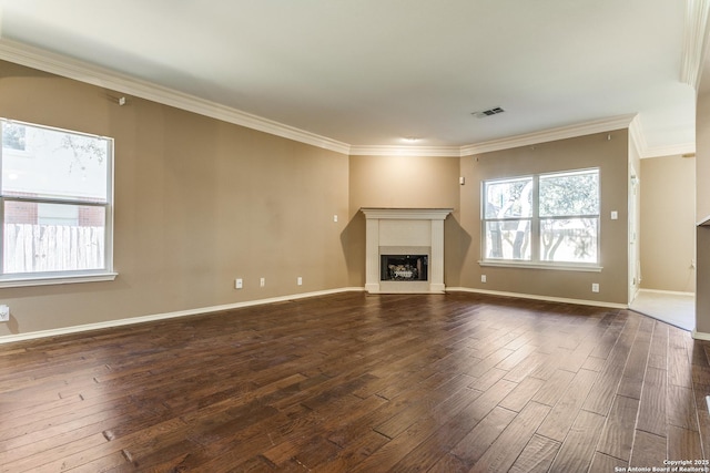 unfurnished living room featuring dark hardwood / wood-style flooring, crown molding, and a wealth of natural light