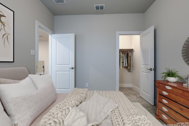 carpeted bedroom featuring a walk in closet