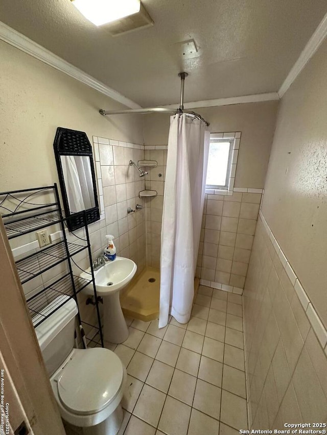 bathroom featuring crown molding, curtained shower, and tile walls