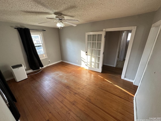 empty room with wood-type flooring, a textured ceiling, and ceiling fan