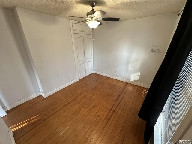 unfurnished bedroom with a closet, ceiling fan, hardwood / wood-style floors, and a textured ceiling