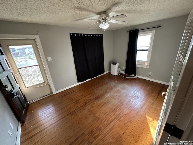 empty room with ceiling fan, hardwood / wood-style floors, and a textured ceiling