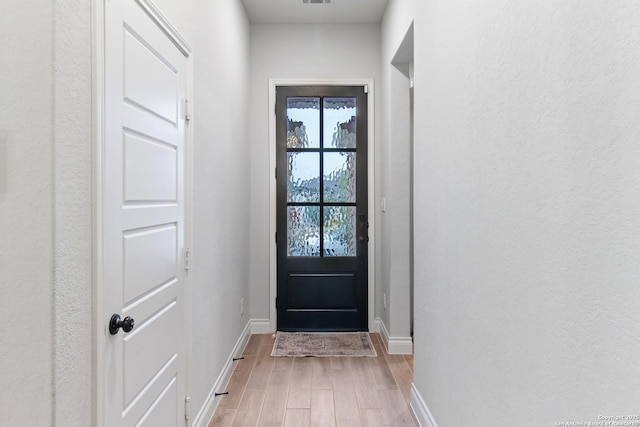 doorway to outside with a healthy amount of sunlight and light wood-type flooring