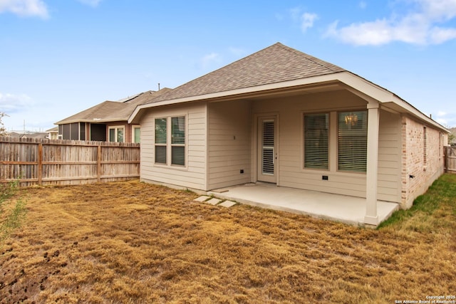 rear view of house featuring a lawn and a patio