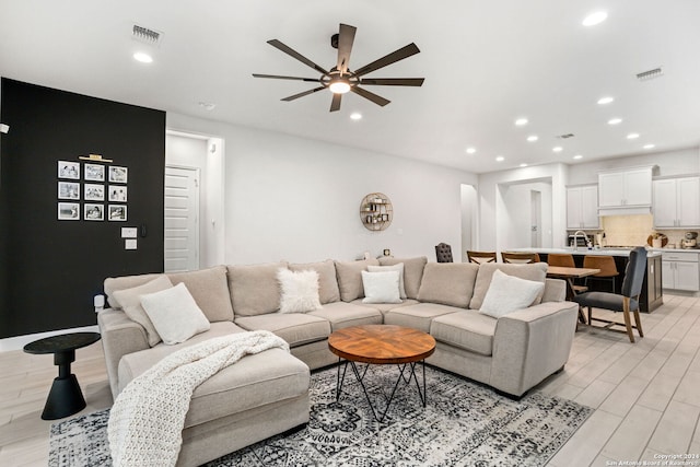 living room with light hardwood / wood-style floors and ceiling fan