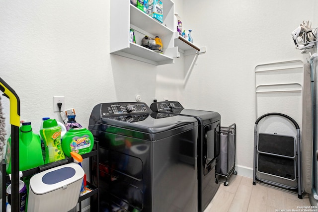 laundry room featuring independent washer and dryer and light hardwood / wood-style floors