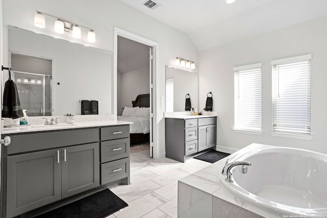 bathroom featuring vanity, vaulted ceiling, and independent shower and bath